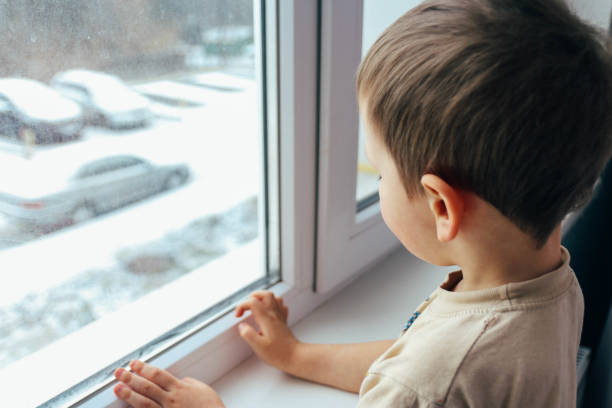 istock the boy looks out the window 945824990