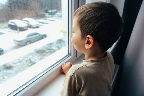 istock the boy looks out the window 945825018