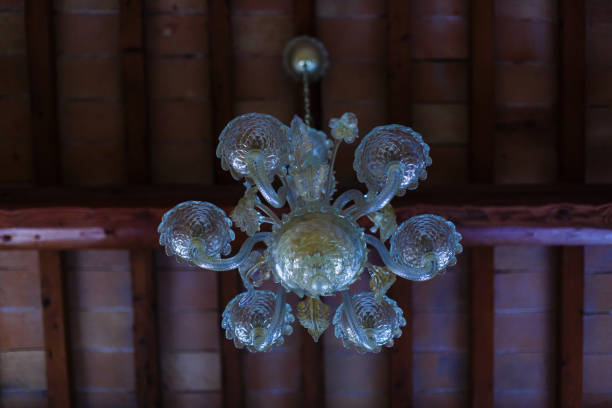 An old retro chandelier is on the ceiling. A wrought iron chandelier hangs on chains. A traditional lighting device. An old retro chandelier is on the ceiling. A wrought iron chandelier hangs on chains. A traditional lighting device. antler chandelier stock pictures, royalty-free photos & images