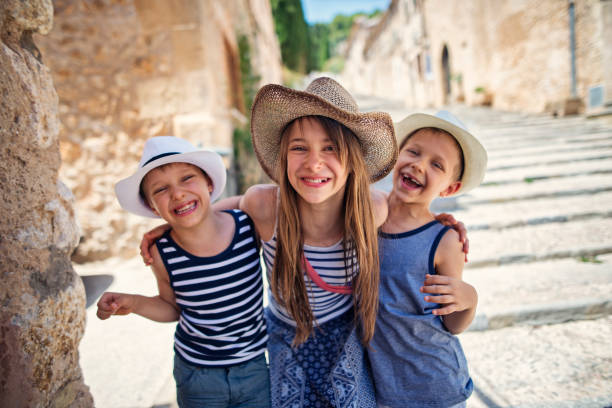 istock Kids having fun sightseeing the beautiful mediterranean town 945852562