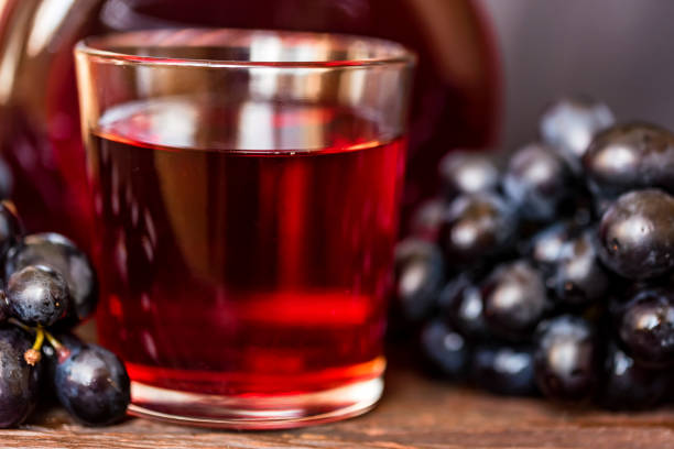 istock Red grape juice in glass and grapes close 945853070