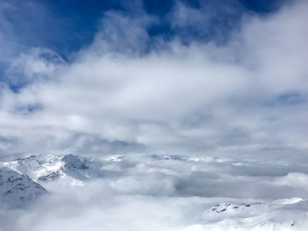 istock Snowcapped Swiss Alps covered in clouds 945860876