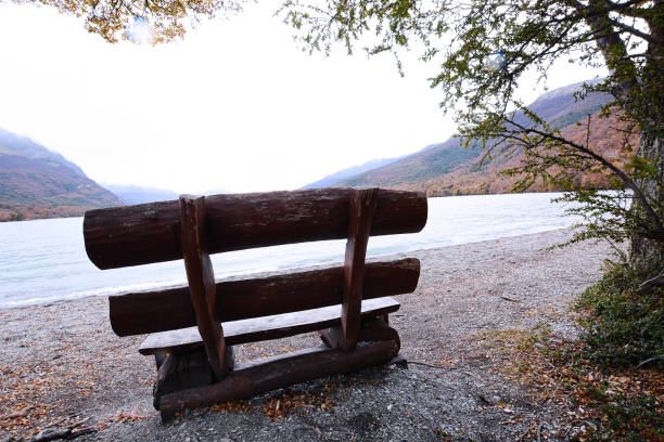 istock Bench near mountain lake. 945869610
