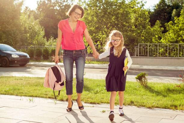 istock Mother and daughter student walking to school. 945869836
