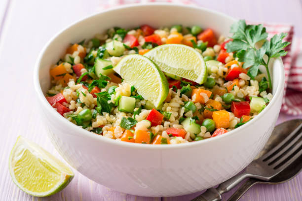 istock Fresh salad with bulgur and vegetables in bowl on wooden table 945878408