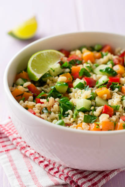istock Fresh salad with bulgur and vegetables in bowl on wooden table 945880932