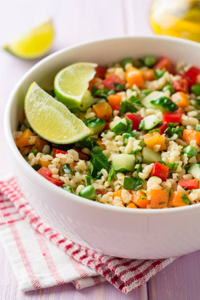 istock Fresh salad with bulgur and vegetables in bowl on wooden table 945881002