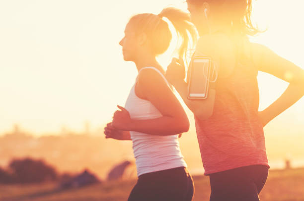 istock Two women running together in the park. 945881726