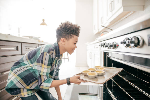 istock Teenage boy baking cookies 945885592