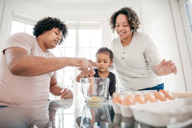 istock Father and Mother Teaching Their Daughter How to Bake 945885674