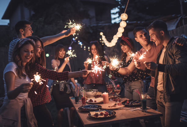 gruppo di amici che cenano nel cortile di casa - festa in giardino foto e immagini stock