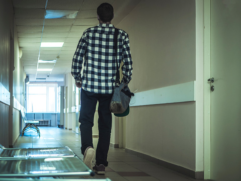 man walking in the hospital corridor alone