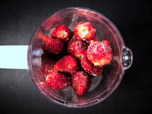 istock fresh iced juicy strawberries in blender top down view on dark surface 945905024