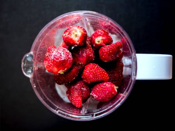istock fresh iced juicy strawberries in blender top down view on dark surface 945905072
