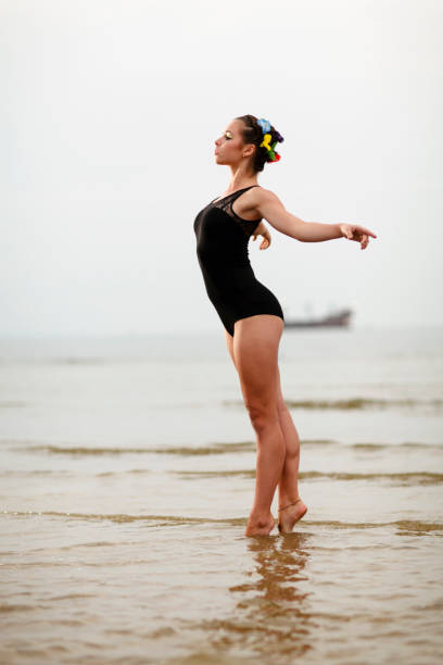 Young beautiful female gymnast training on a beach at Baltic Sea, Swinoujscie, Poland.