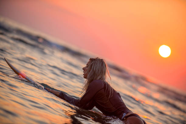 istock Female surfer floating on water. 945908724