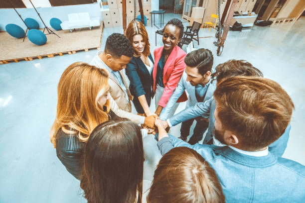 istock Group of business people cheering and holding hands 945909432