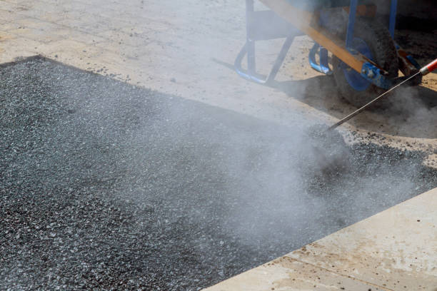 istock Workers team throw asphalt with shovels at road construction 945916810