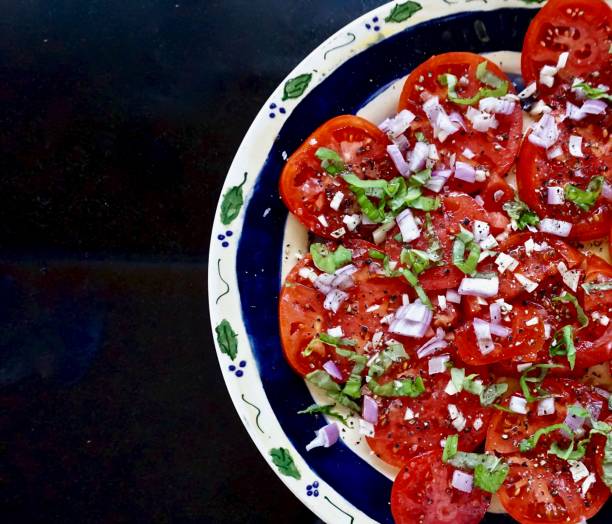 istock plate of sliced tomatoes and fresh herbs 945925368