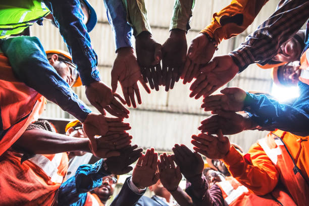 istock Steel Industry workers coming together in a circle as a teamwork exercise. 945926276