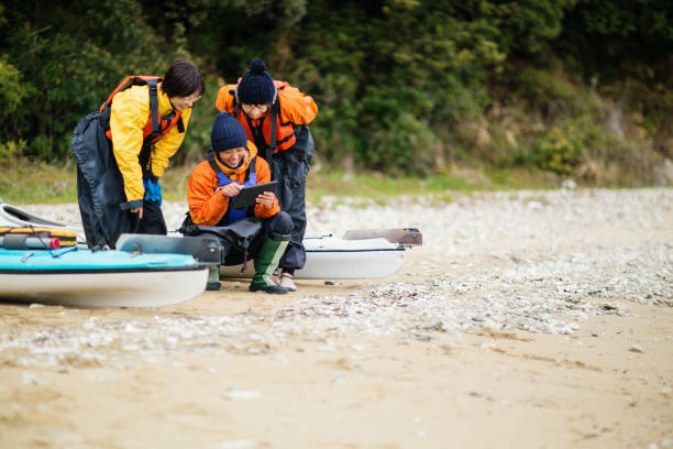 istock A small group of female kayakers using a digital tablet on a beach 945928616