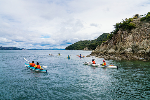 A group of men and women sea kayaking