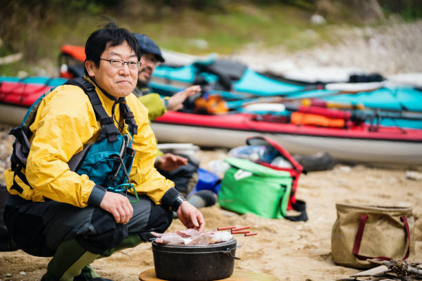 Sea kayaker cooking and preparing lunch on a beach
