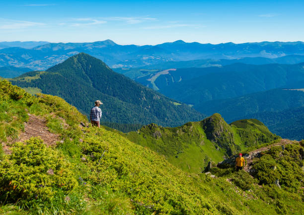 istock Father and his small son are standing on a green mountain ridge 945931818