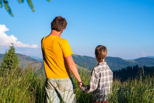 istock Father and his small son stand on the mountain meadow 945931876