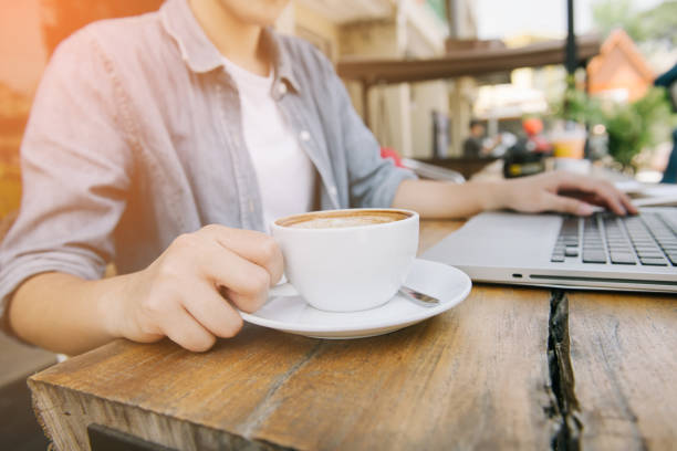 istock Beautiful hipster woman using laptop at cafe 945932712