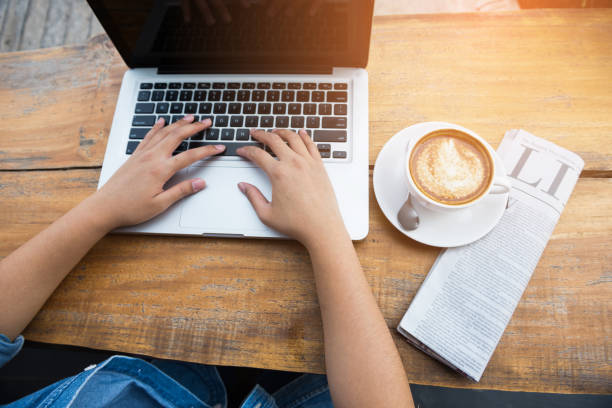 istock Beautiful hipster woman using laptop at cafe 945932774