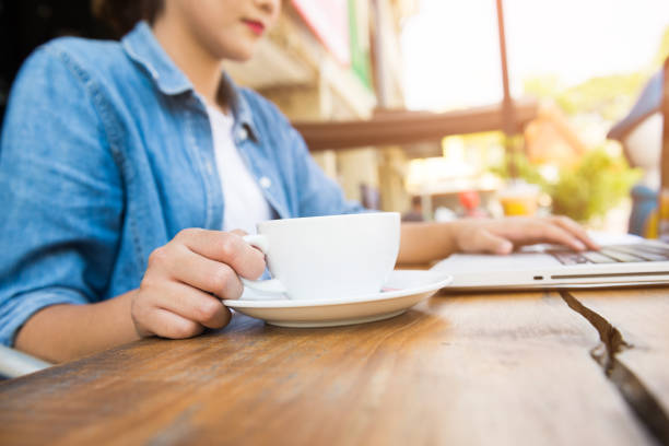 istock Beautiful hipster woman using laptop at cafe 945935106