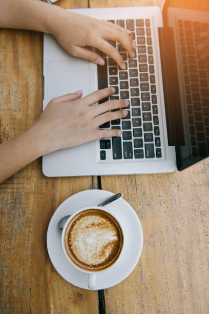 istock Beautiful hipster woman using laptop at cafe 945935320