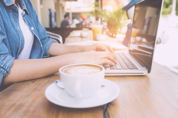 istock Beautiful hipster woman using laptop at cafe 945935754