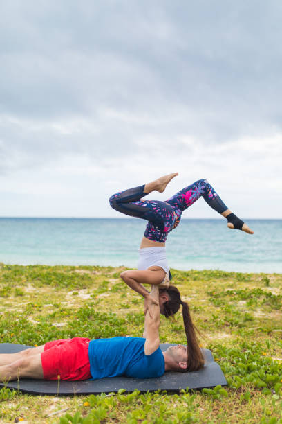istock Yoga acrobatic couple by the ocean 945944780