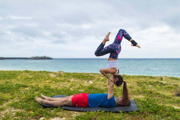 istock Yoga acrobatic couple by the ocean 945944788