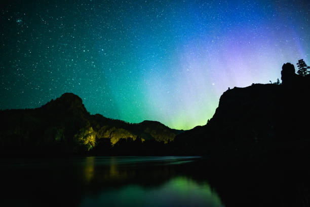 Northern Lights Over Mountains and Water stock photo