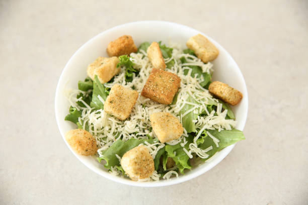 Deconstructed Caesar salad ingredients with neat geometry isolated on white background.
