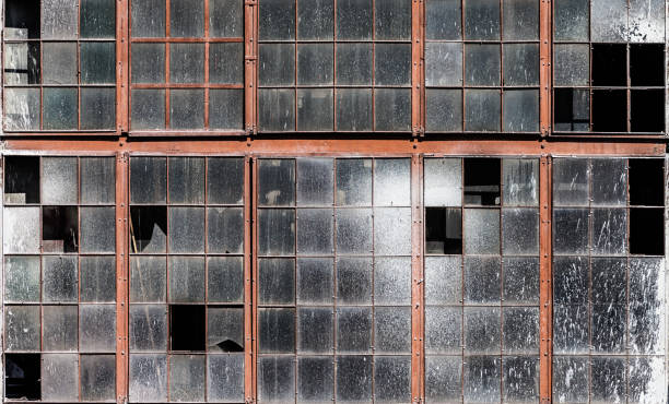 istock Old building wall with dirty broken windows glass 945948568