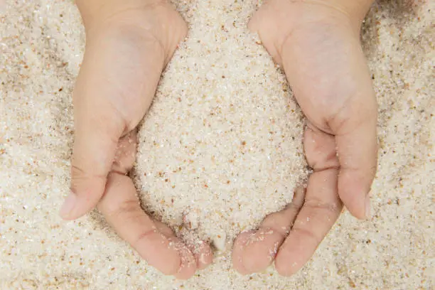Summer holiday concept. Top view of child hands holding sand in the beach