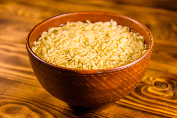 istock Ceramic bowl with prepared instant noodles on wooden table 945958210