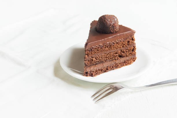 Piece of Chocolate Cake on plate and white background, copy space. Homemade chocolate cake.