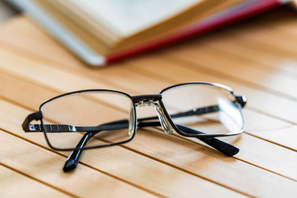 istock Open book and glasses on wooden table close 945971602