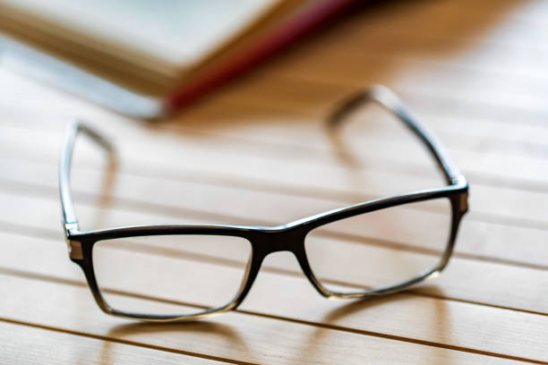 istock Open book and glasses on wooden table close 945971610
