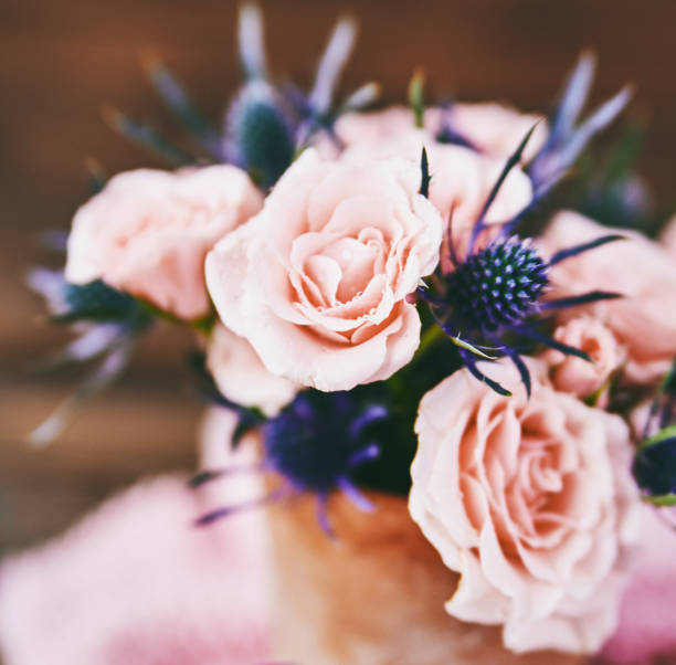 istock Mother's Day bouquet with pink roses in rustic pottery vase 945975434