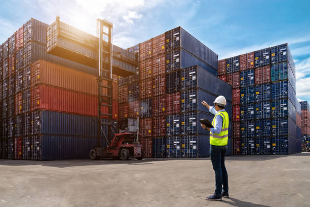 форман контролирует погрузку контейнеров с грузового судна для импорта - warehouse distribution warehouse occupation truck стоковые фото и изображения