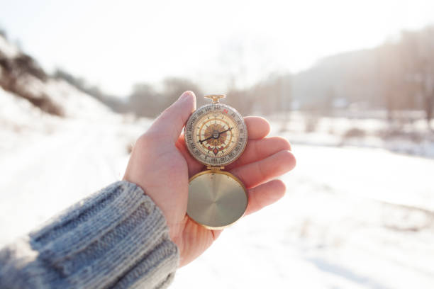 Hand holding a compass, winter time idea, searching direction. stock photo