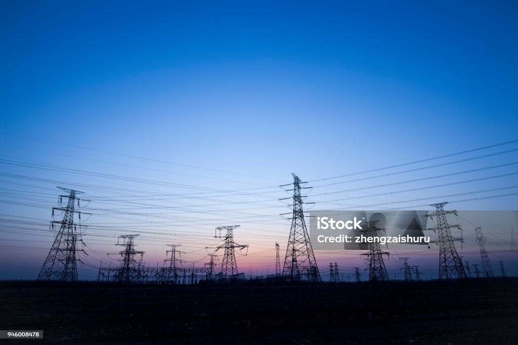 The silhouette of the evening electricity transmission pylon Communications Tower Stock Photo