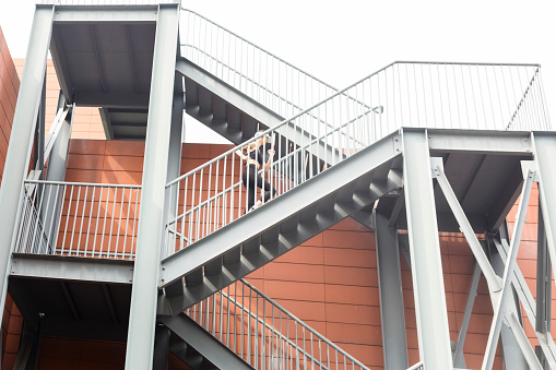 woman running up staircase,China.