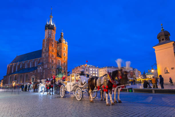 istock Horse carriages at the Main Square in Krakow 946012750